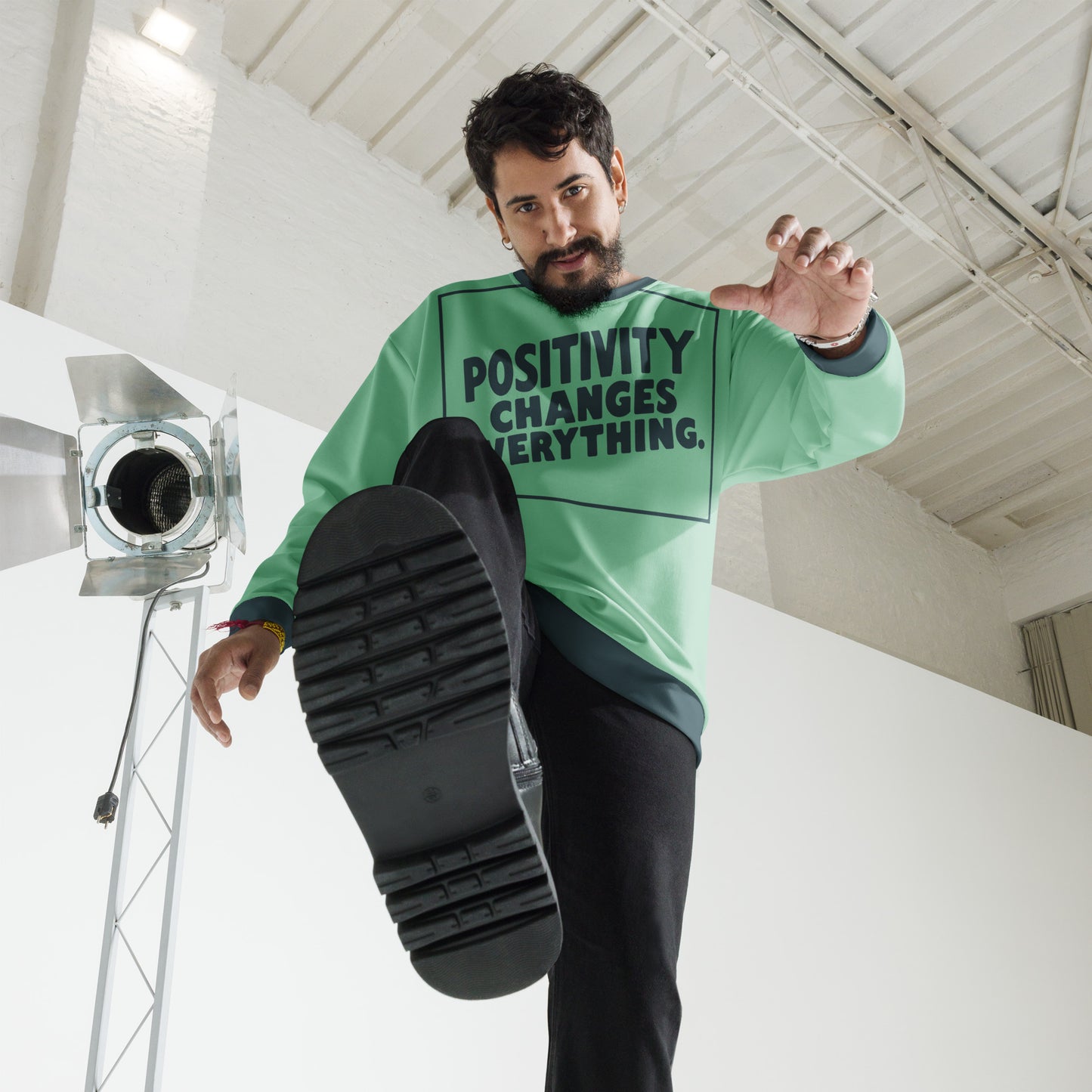 This unisex sweatshirt is a new arrival with "POSITIVITY CHANGES EVERYTHING" in a bold, dark teal tilt. Made with recycled materials for ultimate comfort.