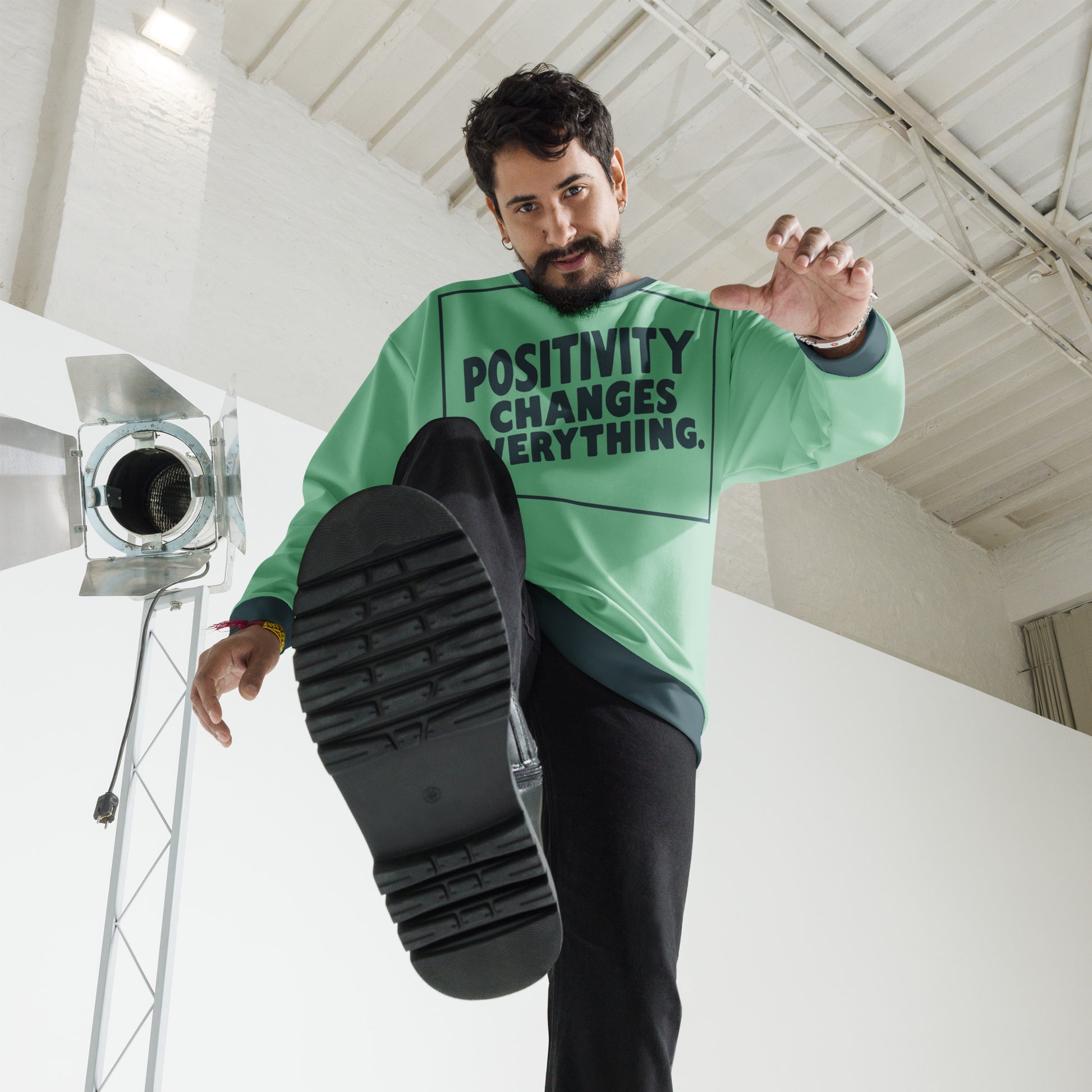 This unisex sweatshirt is a new arrival with "POSITIVITY CHANGES EVERYTHING" in a bold, dark teal tilt. Made with recycled materials for ultimate comfort.