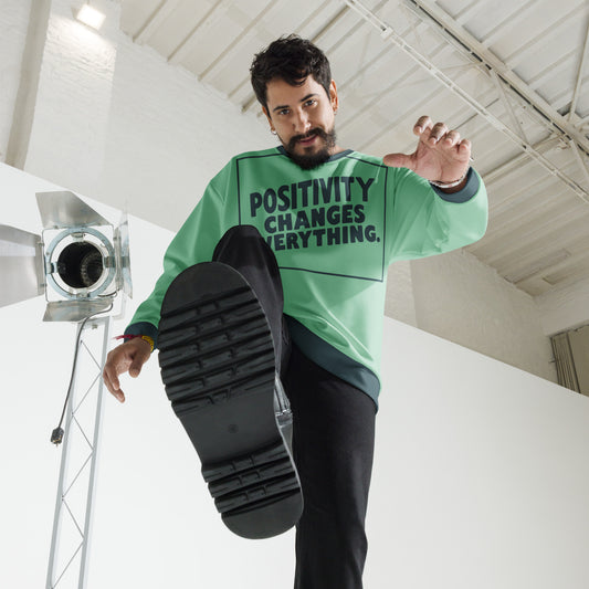 This unisex sweatshirt is a new arrival with "POSITIVITY CHANGES EVERYTHING" in a bold, dark teal tilt. Made with recycled materials for ultimate comfort.